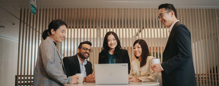 EnterpriseSG officers gathered around a laptop having a discussion