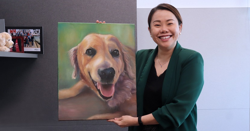Cindy with a painting that she did of her golden retriever, Tae.