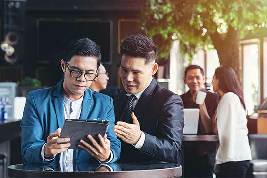 Several groups of people at different cocktail tables having a discussion