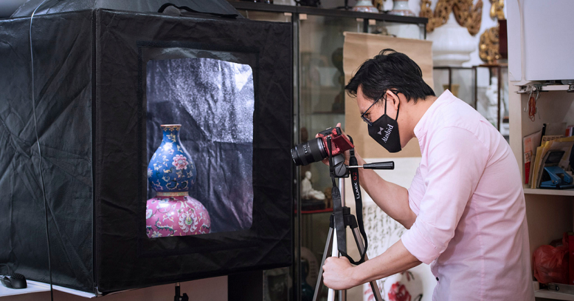 Ahead of upcoming online auctions, staff, including Seng Ngee, busy themselves with taking photos of the art and antiques at Atasbid’s Chinatown headquarters